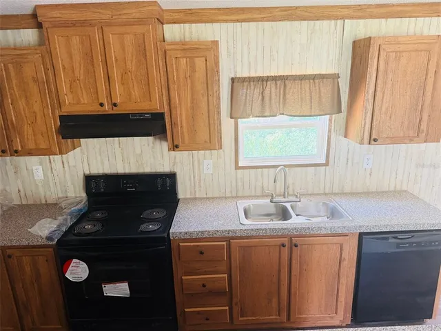 a kitchen with granite countertop white cabinets and black appliances