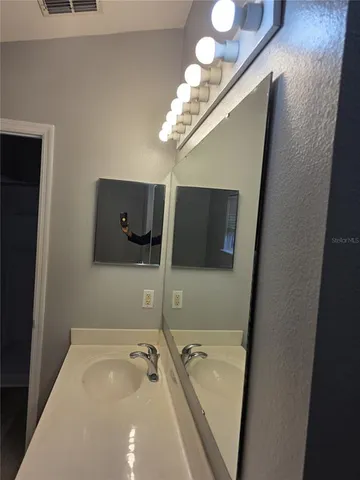 a bathroom with a tub a sink and mirror