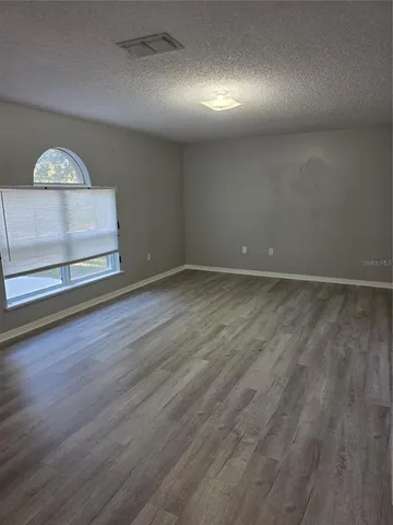 an empty room with wooden floor and glass door