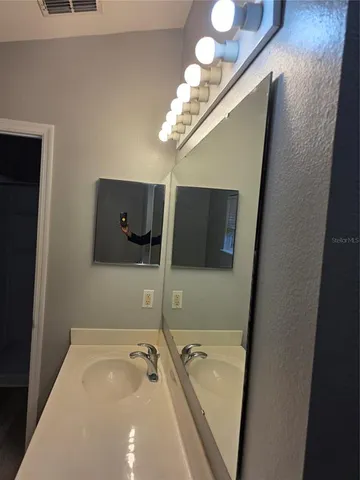 a bathroom with a tub a sink and mirror