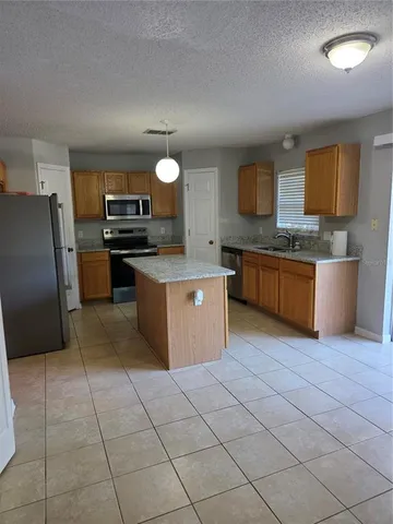 a kitchen with stainless steel appliances granite countertop a stove a sink dishwasher and a refrigerator