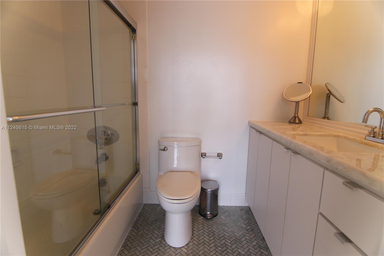 1621 Bay Road, Unit 708 Miami Beach, FL 33139 - Photo 14 of 20 a bathroom with a granite countertop toilet and a sink
