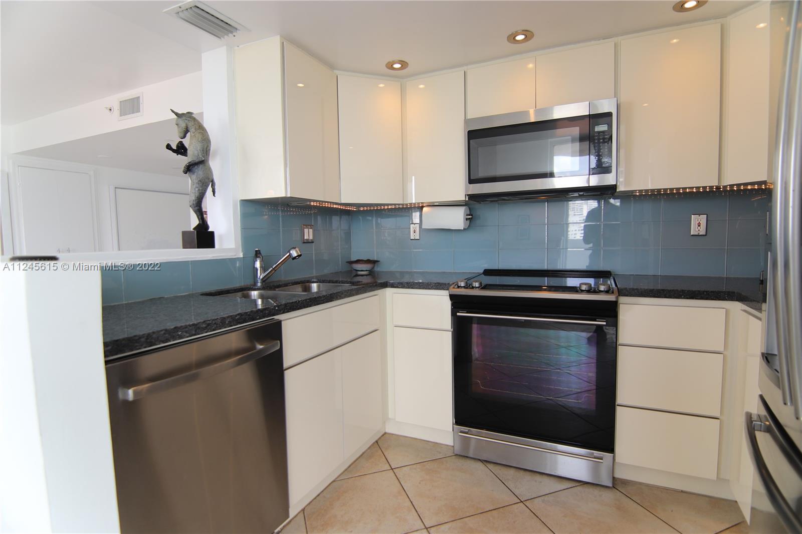 1621 Bay Road, Unit 708 Miami Beach, FL 33139 - Photo 3 of 20 a kitchen with stainless steel appliances granite countertop a sink and a microwave