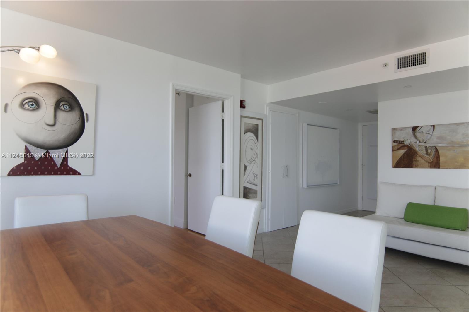 1621 Bay Road, Unit 708 Miami Beach, FL 33139 - Photo 6 of 20 a bedroom with a bed and a chandelier