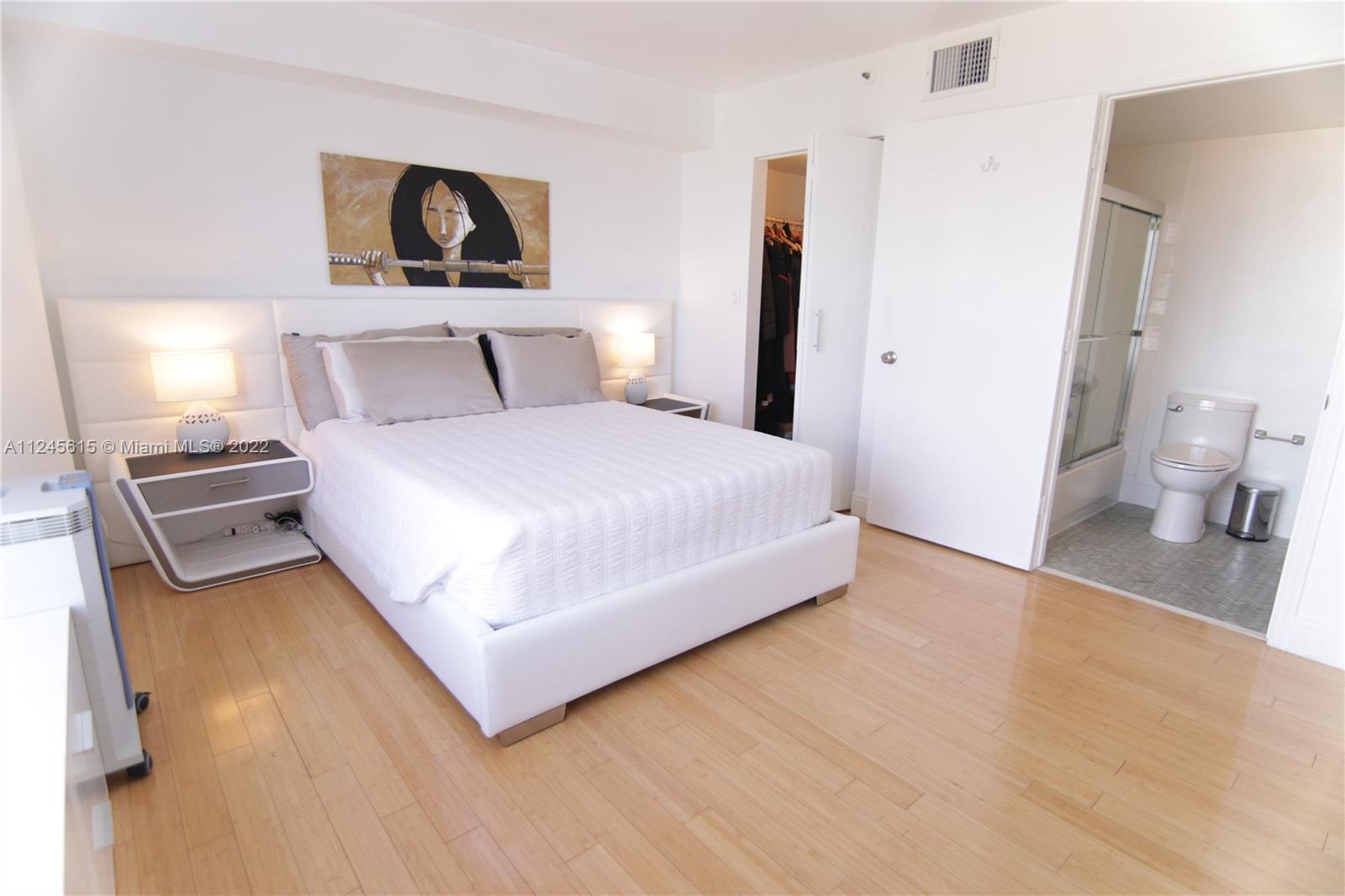 1621 Bay Road, Unit 708 Miami Beach, FL 33139 - Photo 9 of 20 a bedroom with a bed and painting on the wall
