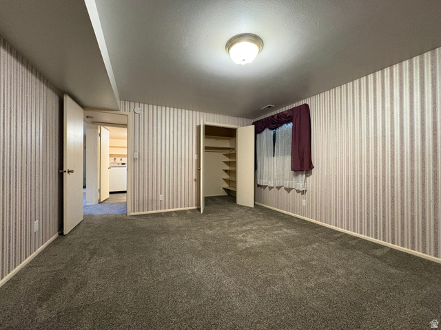595 Meadowlark Road Orem, UT 84097 - Photo 58 of 87 Carpeted room featuring striped wallpaper, a flush-mount ceiling light fixture, and a built-in closet with shelving