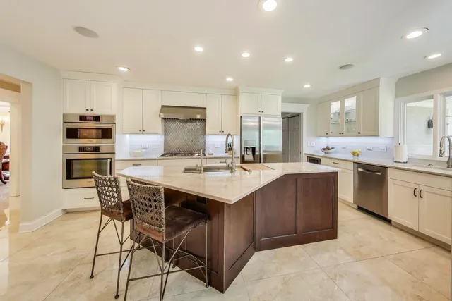 a kitchen with stainless steel appliances kitchen island granite countertop a sink and cabinets