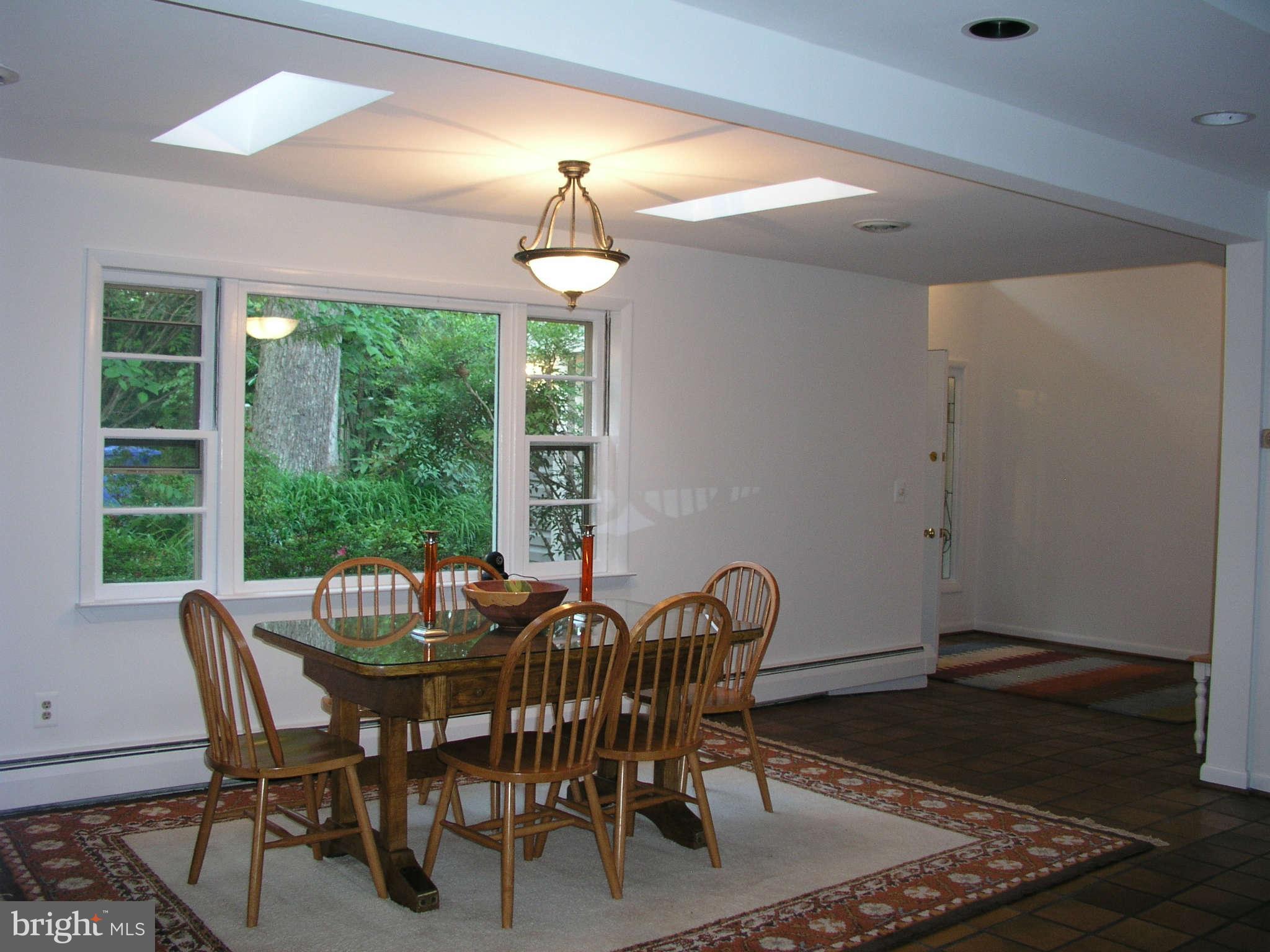 10409 Gary Road, Unit FRONT Potomac, MD 20854 - Photo 6 of 14 a view of a dining room with furniture wooden floor and chandelier