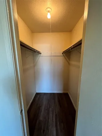 a close view of walk in closet with wooden floor