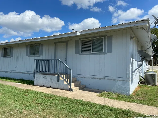 a backyard of a house with table and chairs