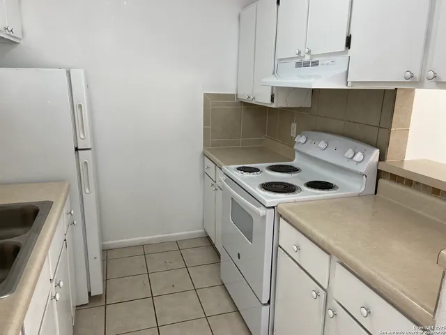 a kitchen with a stove and a refrigerator