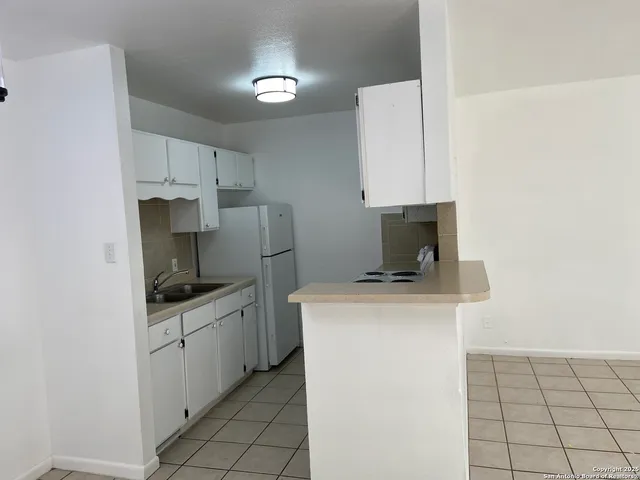a kitchen with a stove a sink and a refrigerator
