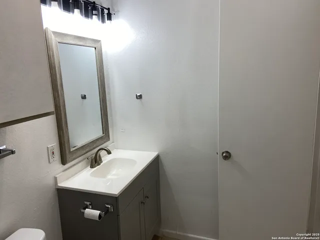 a bathroom with a sink a toilet and mirror