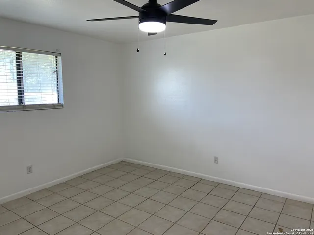 an empty room with chandelier fan