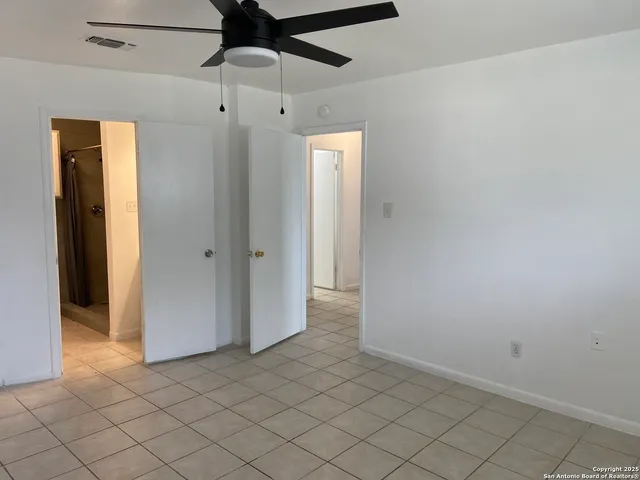 an empty room and chandelier fan