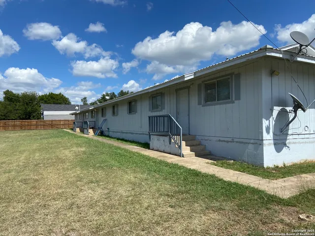 a backyard of a house with table and chairs