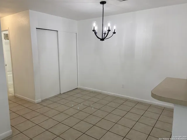 an empty room with chandelier fan