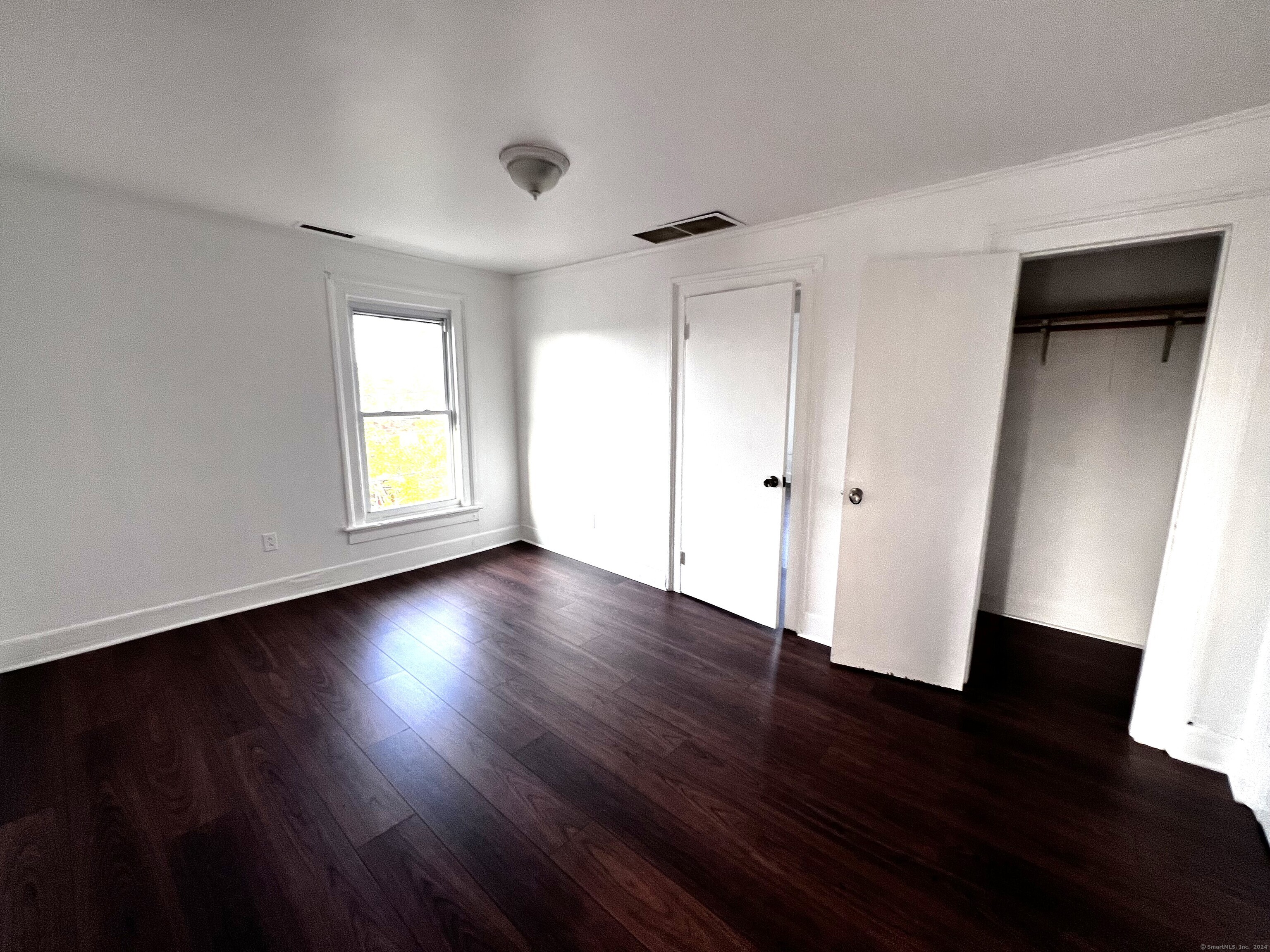 83 Seeley Street, Unit 3 Bridgeport, CT 06604 - Photo 11 of 12 an empty room with wooden floor and windows