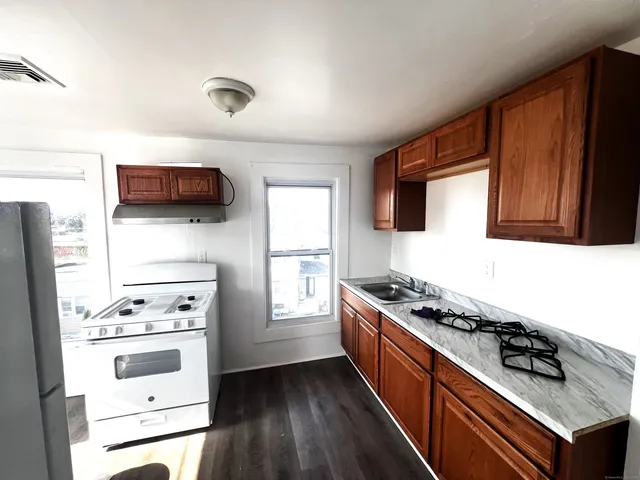 a kitchen with stainless steel appliances a stove a microwave a sink and cabinets