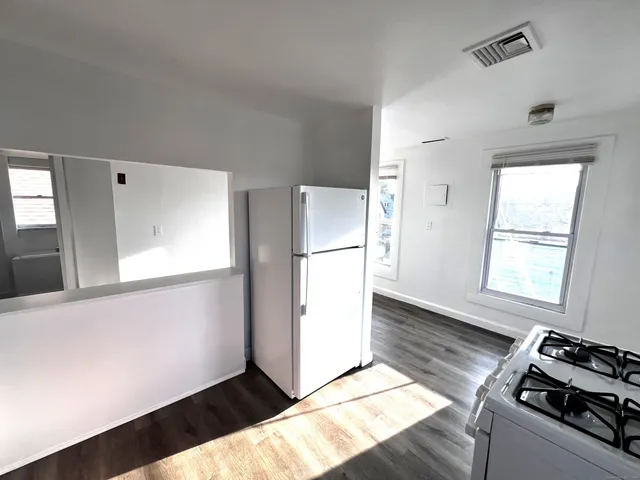 a kitchen with a refrigerator and a stove top oven