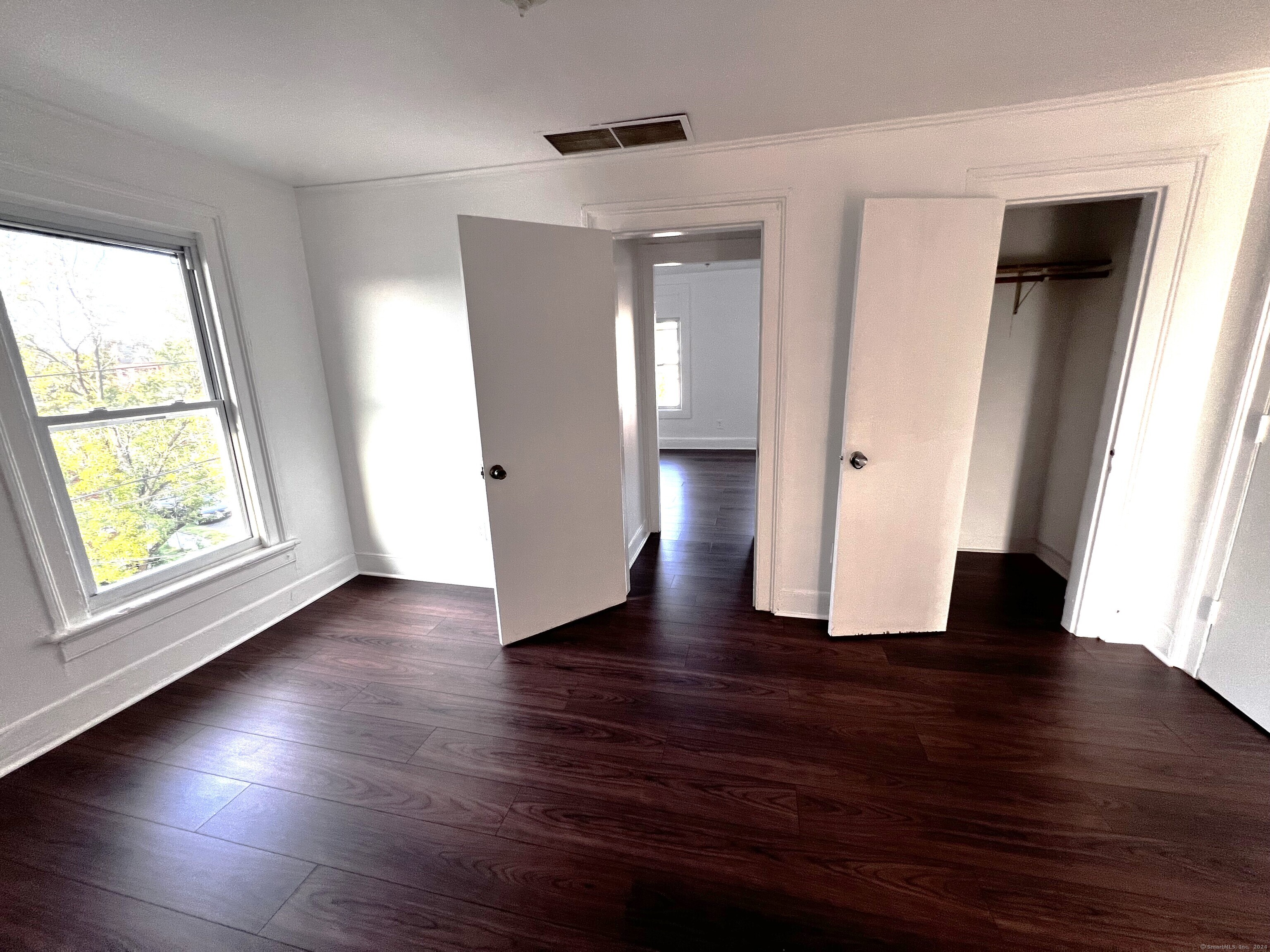 83 Seeley Street, Unit 3 Bridgeport, CT 06604 - Photo 7 of 12 an empty room with wooden floor and windows