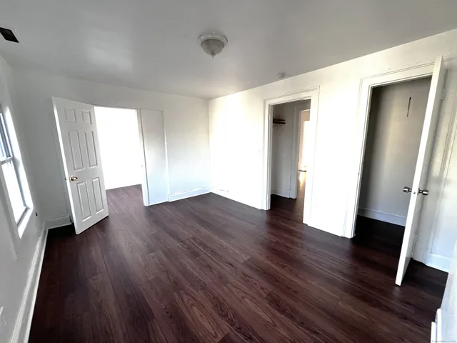 an empty room with wooden floor and a window