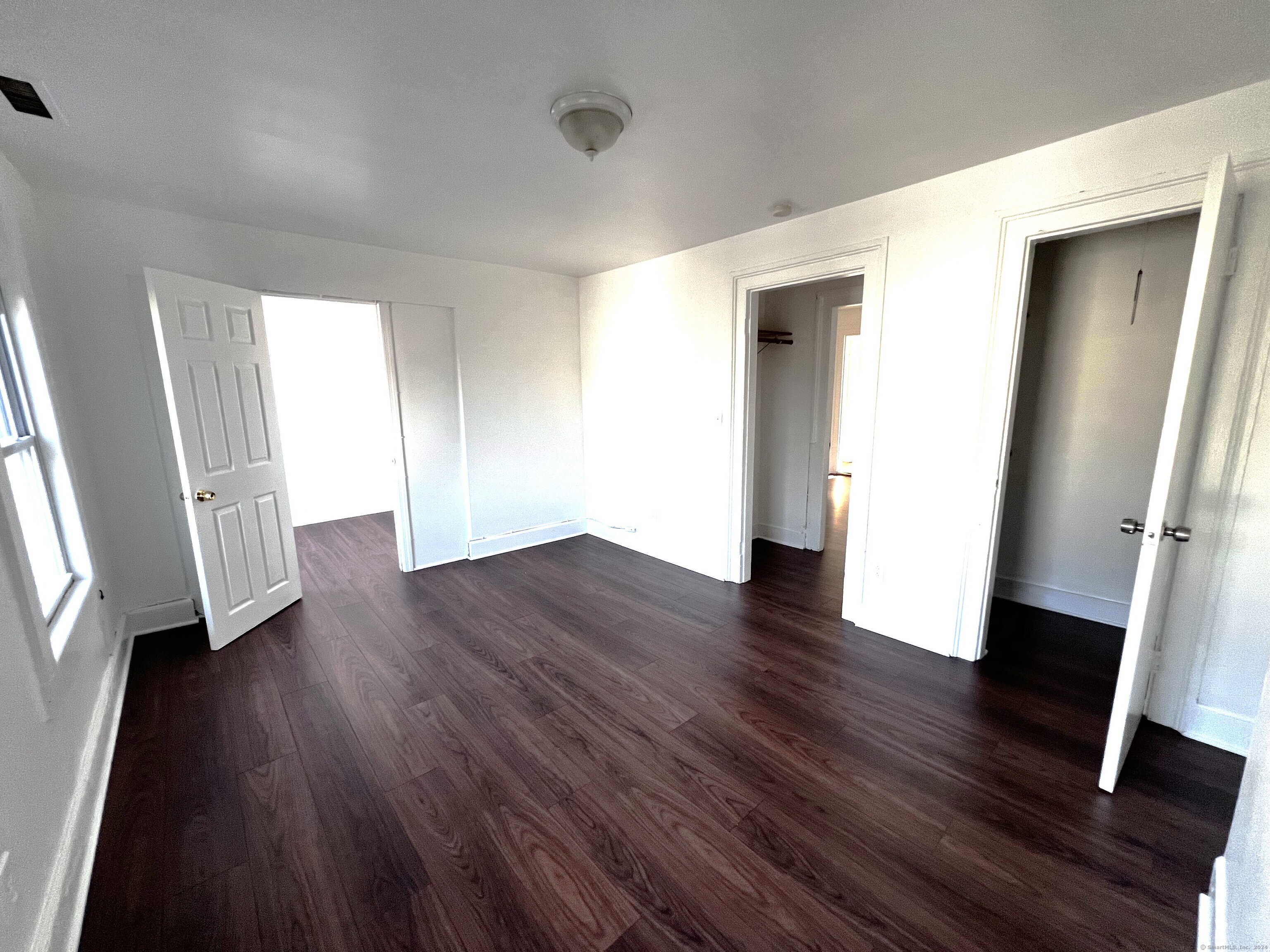 83 Seeley Street, Unit 3 Bridgeport, CT 06604 - Photo 8 of 12 an empty room with wooden floor and a window