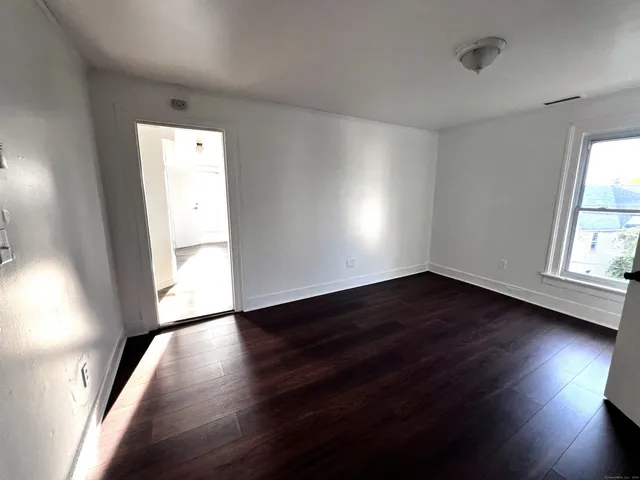 wooden floor in an empty room with a window