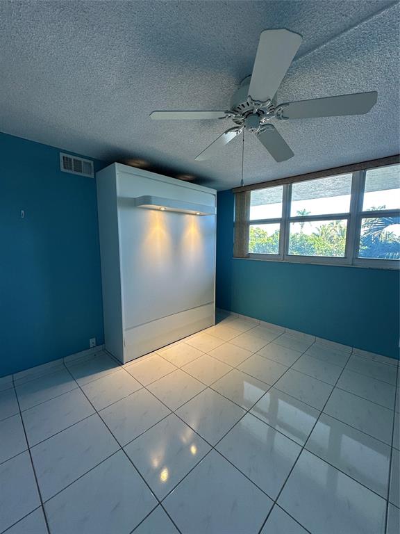 5300 Northeast 24th Terrace, Unit 211C Fort Lauderdale, FL 33308 - Photo 11 of 23 a view of an empty room with window and chandelier fan