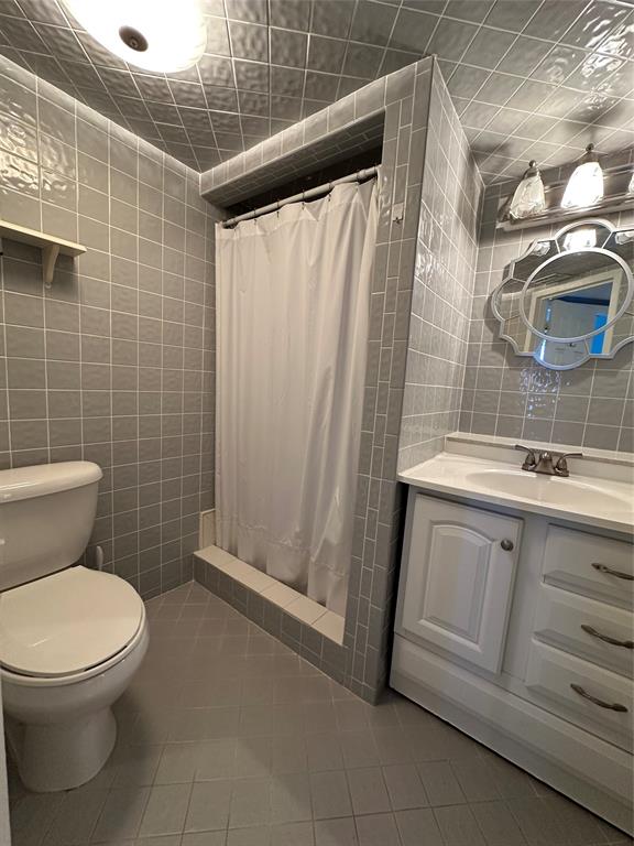 5300 Northeast 24th Terrace, Unit 211C Fort Lauderdale, FL 33308 - Photo 8 of 23 a bathroom with a granite countertop sink toilet and shower