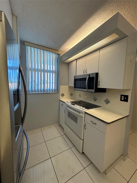 5300 Northeast 24th Terrace, Unit 211C Fort Lauderdale, FL 33308 - Photo 9 of 23 a kitchen with a sink and cabinets