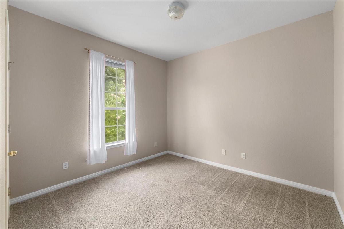 11000 Anderson Mill Road, Unit 11 Austin, TX 78750 - Photo 19 of 34 A well-lit bedroom features plush carpeting and a large window providing verdant outdoor views.