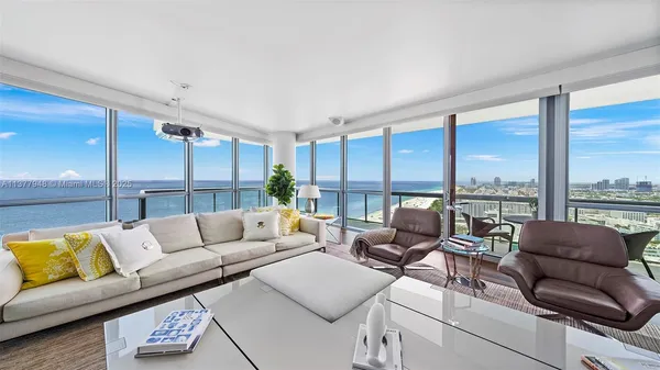 a living room with furniture kitchen view and a large window