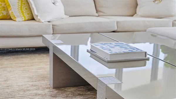a living room with furniture a flat screen tv and a floor to ceiling window
