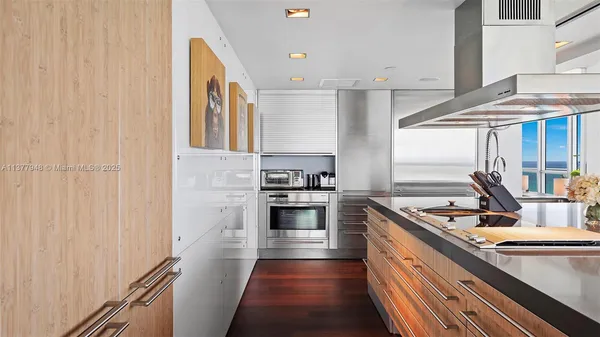 a kitchen with stainless steel appliances granite countertop a sink and white cabinets