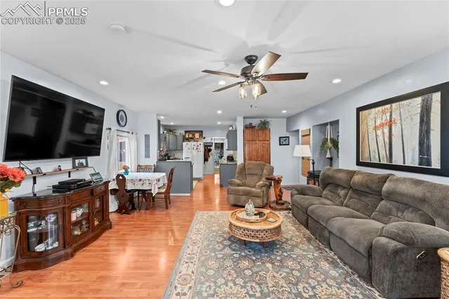 a living room with furniture kitchen view and a flat screen tv