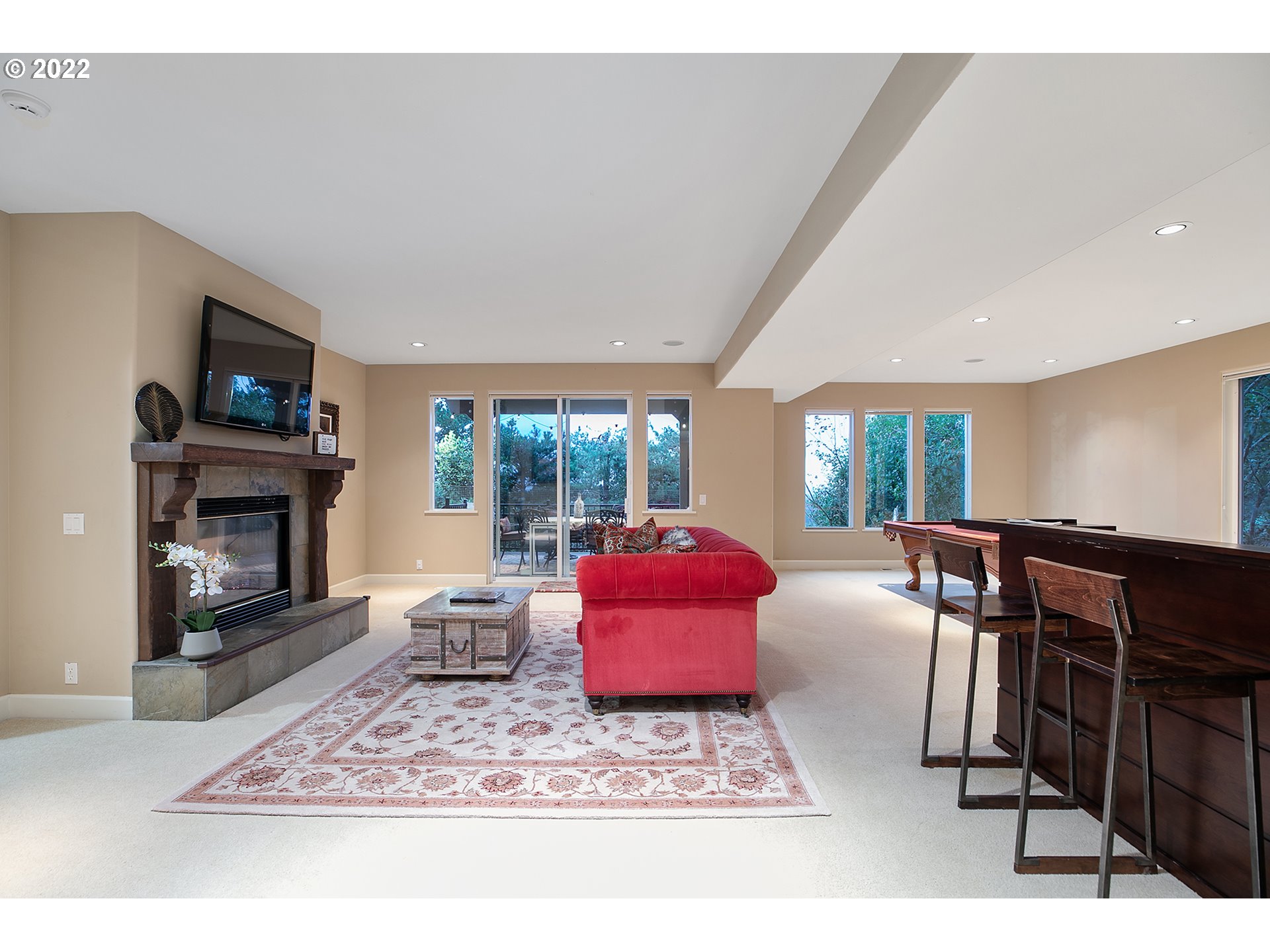 4027 Northwest Devoto Lane Portland, OR 97229 - Photo 29 of 48 a living room with furniture a rug a fireplace and a flat screen tv