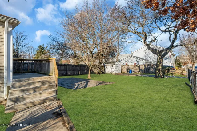 a view of a backyard with wooden fence