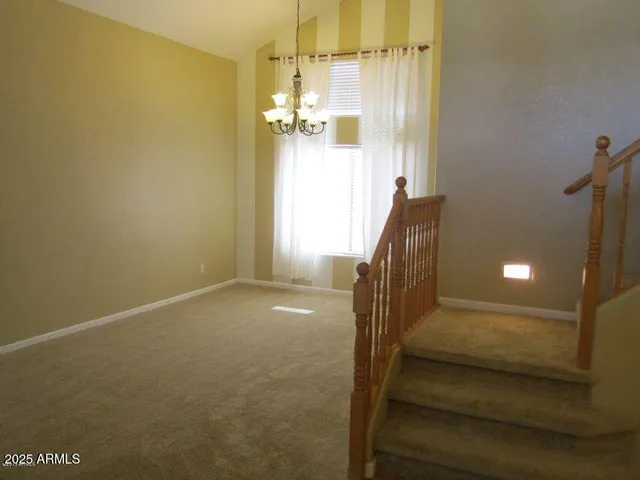 a view of a hallway with wooden floor and chandelier