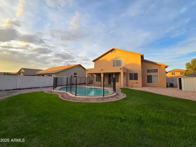 a view of a house with a big yard potted plants and a large tree