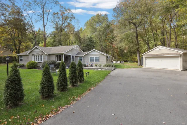 a front view of a house with a yard and lake view