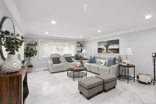 a living room with furniture a large window and a potted plant