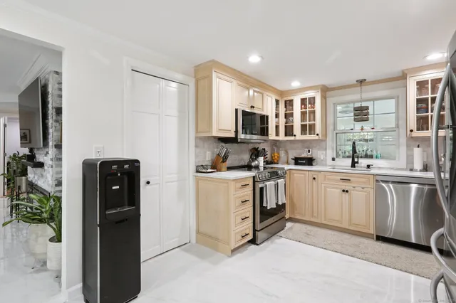 a kitchen with white cabinets and black appliances