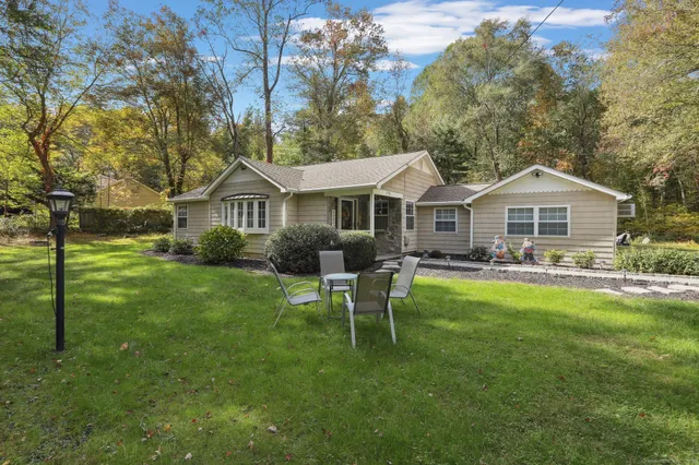 a front view of a house with a garden and trees