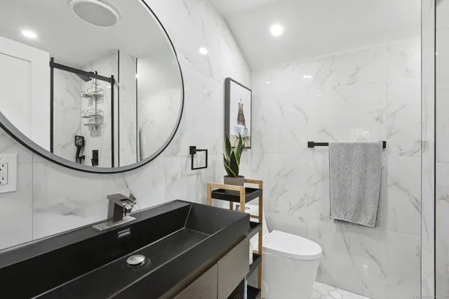 a bathroom with a sink a toilet and a mirror