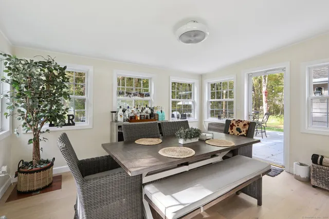 a view of a dining room and livingroom with furniture wooden floor and a large window
