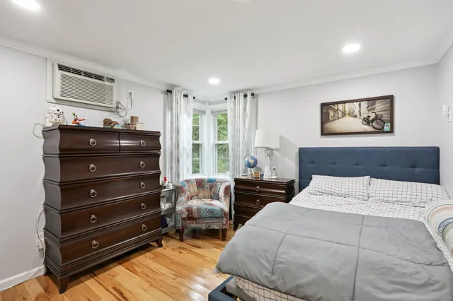a bedroom with a bed and wooden floor