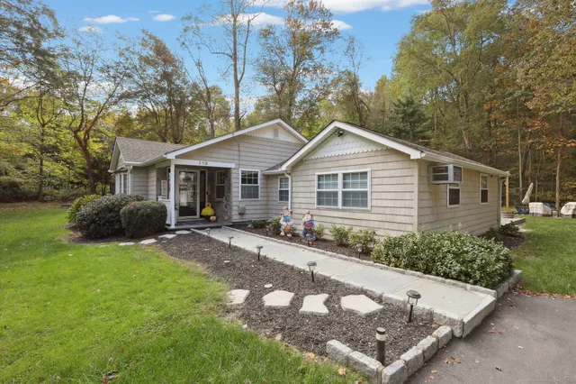 a front view of a house with yard and green space