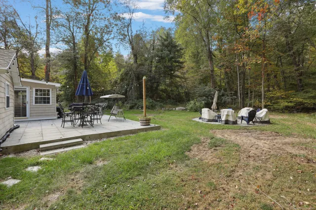 a view of a chair and table in backyard of the house