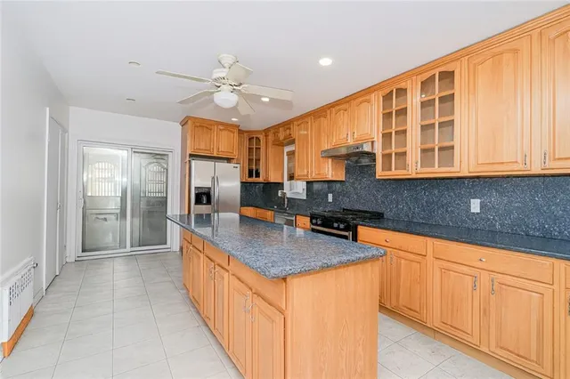 a large kitchen with stainless steel appliances granite countertop a sink and cabinets